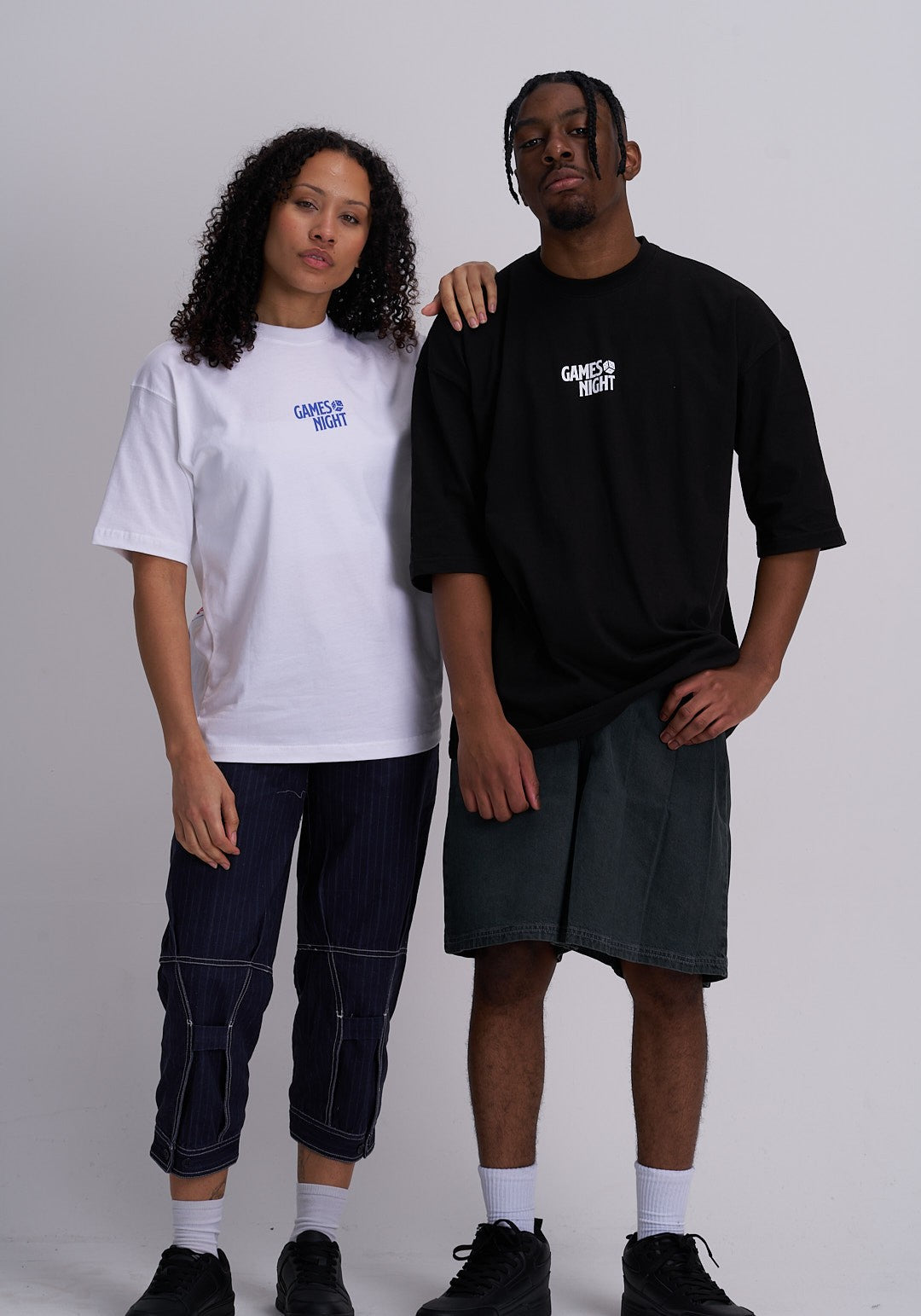 Man and woman wearing t-shirts with "games night" text against a plain background