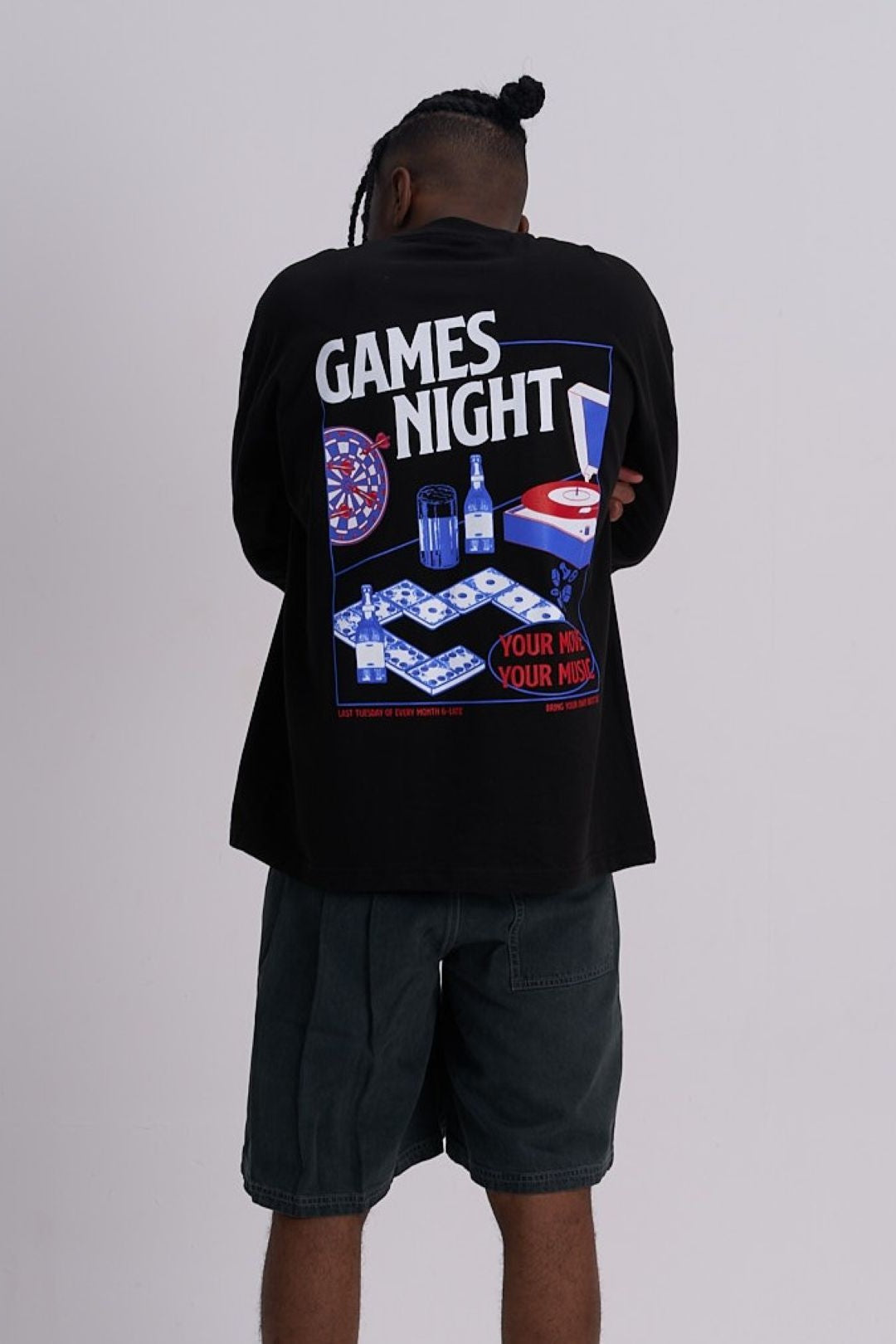 Man wearing a black t-shirt with a colourful games night graphic on the back against a grey background