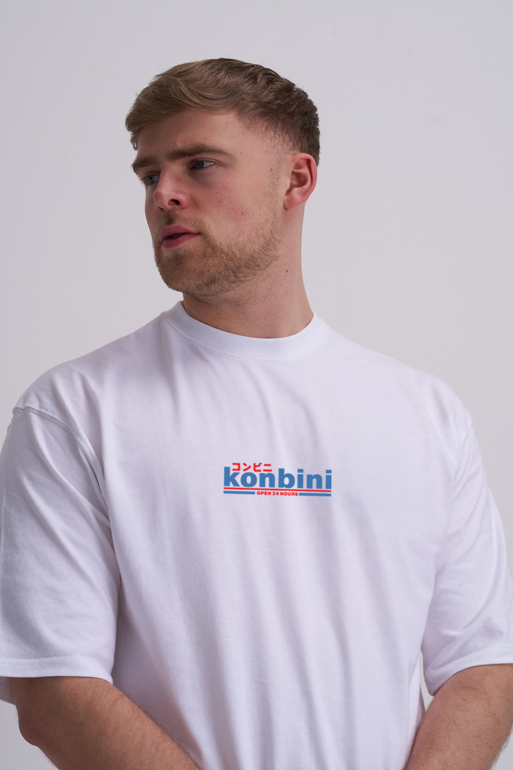 Man wearing a white t-shirt with 'konbini' text logo on a plain background