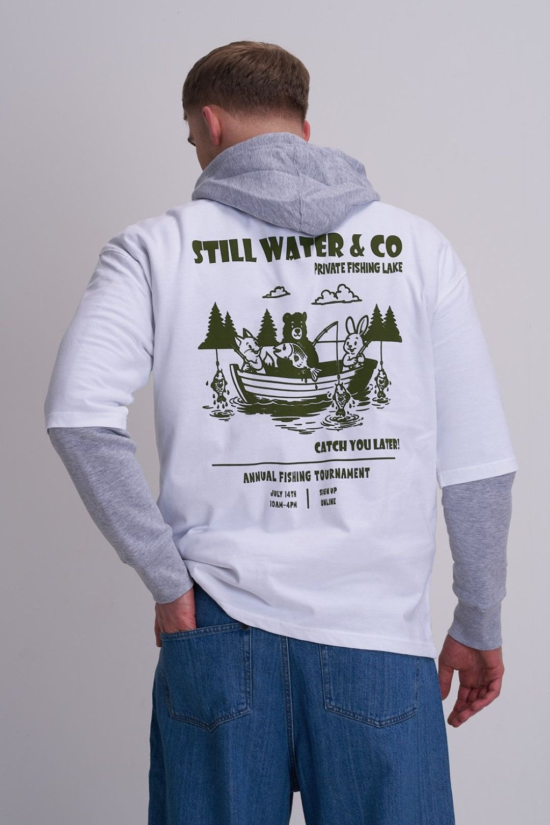 Man wearing a hoodie with a white t-shirt on top - graphic design on the back is of a fishing boat against a grey background