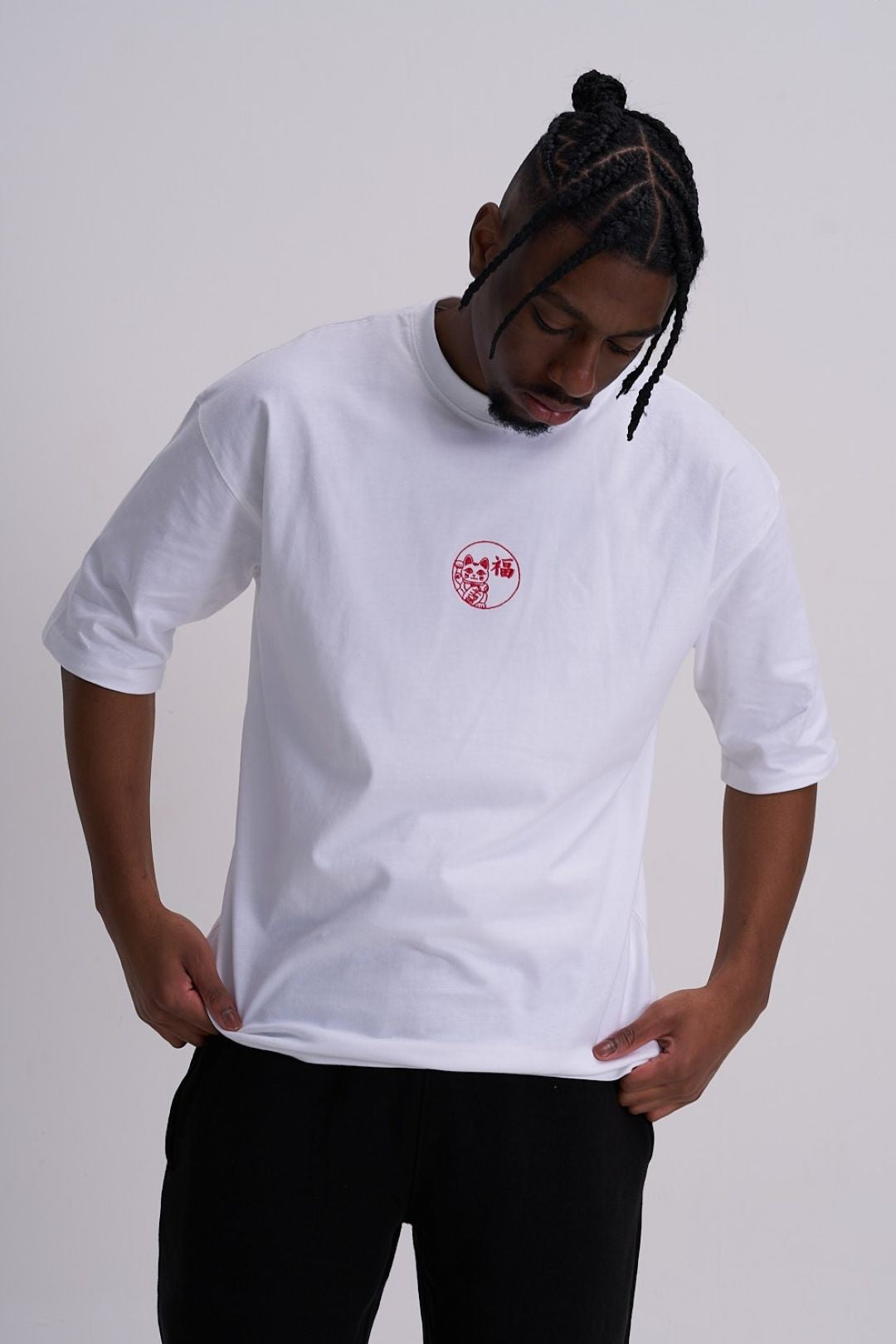 Male wearing a white t-shirt with a red logo on a plain background