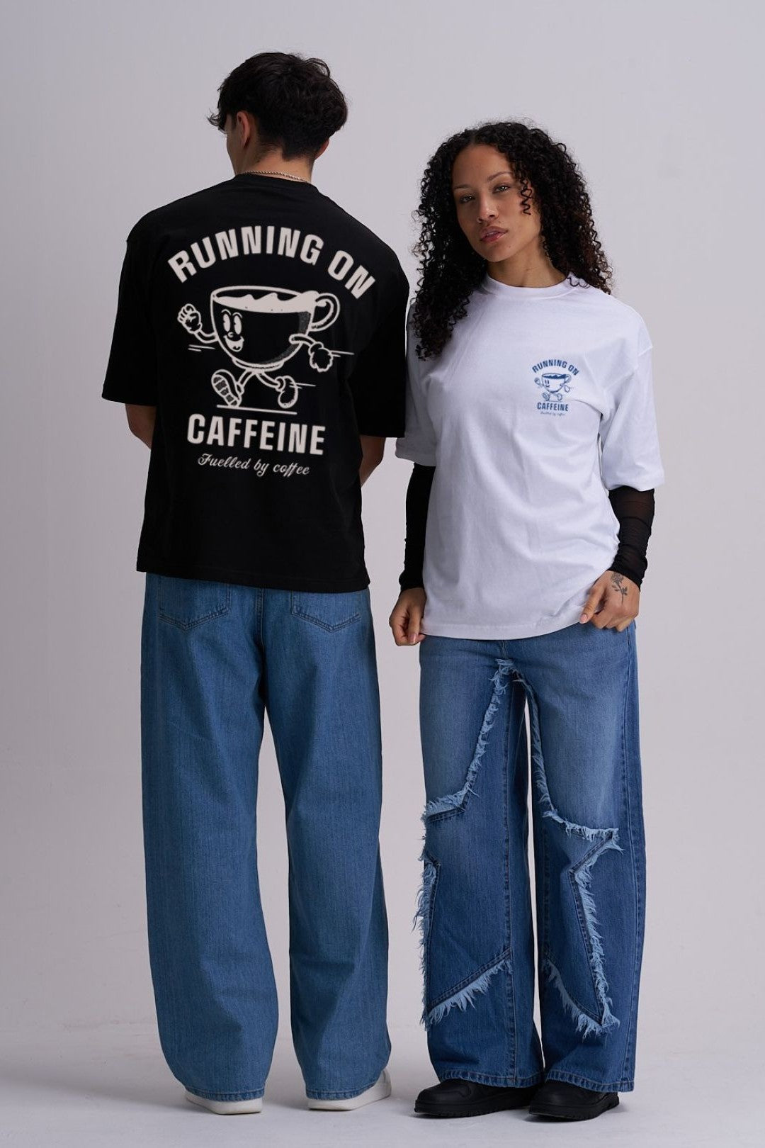 Two people wearing t-shirts with "running on caffeine" text and cartoon cup graphics, standing side by side against a plain background.
