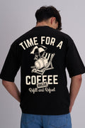 Person wearing a black t-shirt with a coffee cup on a deckchair design on the back and time for a coffee break text