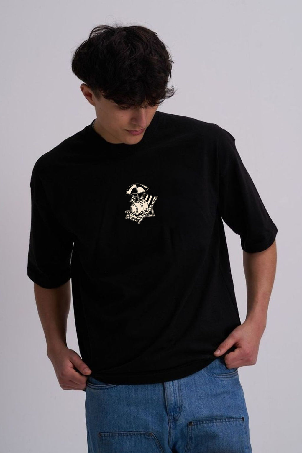 Person wearing a black t-shirt with a coffee cup on a deckchair design 