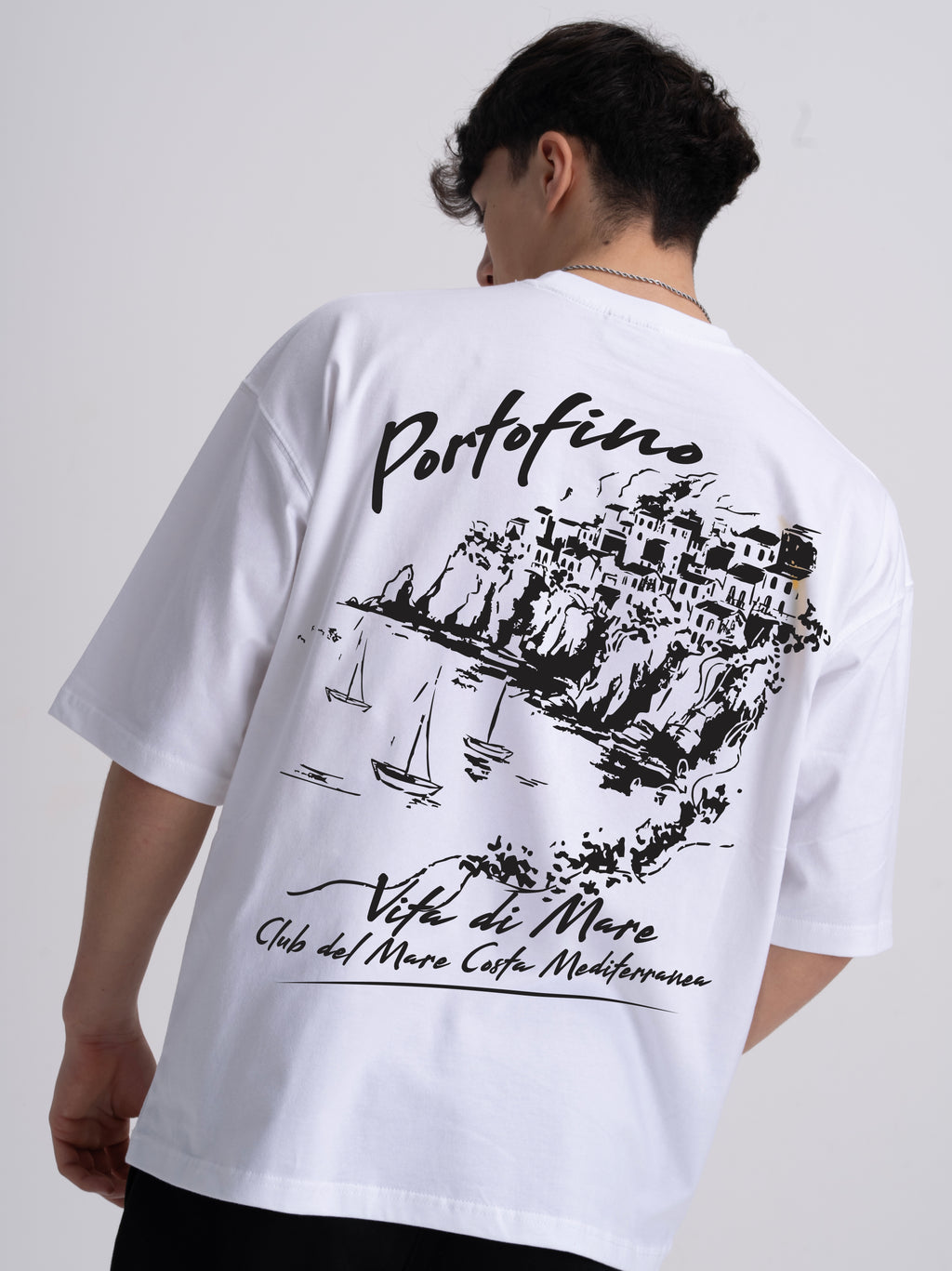 Male wearing a white t-shirt with black coastal line drawing and Portofino text on the back