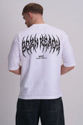 A man wearing a white t-shirt viewed from the back, featuring a large black 'BORN READY' text graphic, paired with dark jeans against a light grey background.