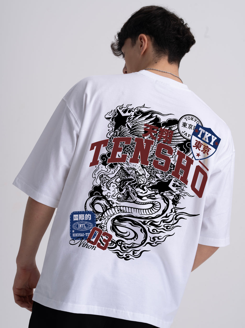 Male wearing a white t-shirt with a Japanese dragon design and Tensho text on the back