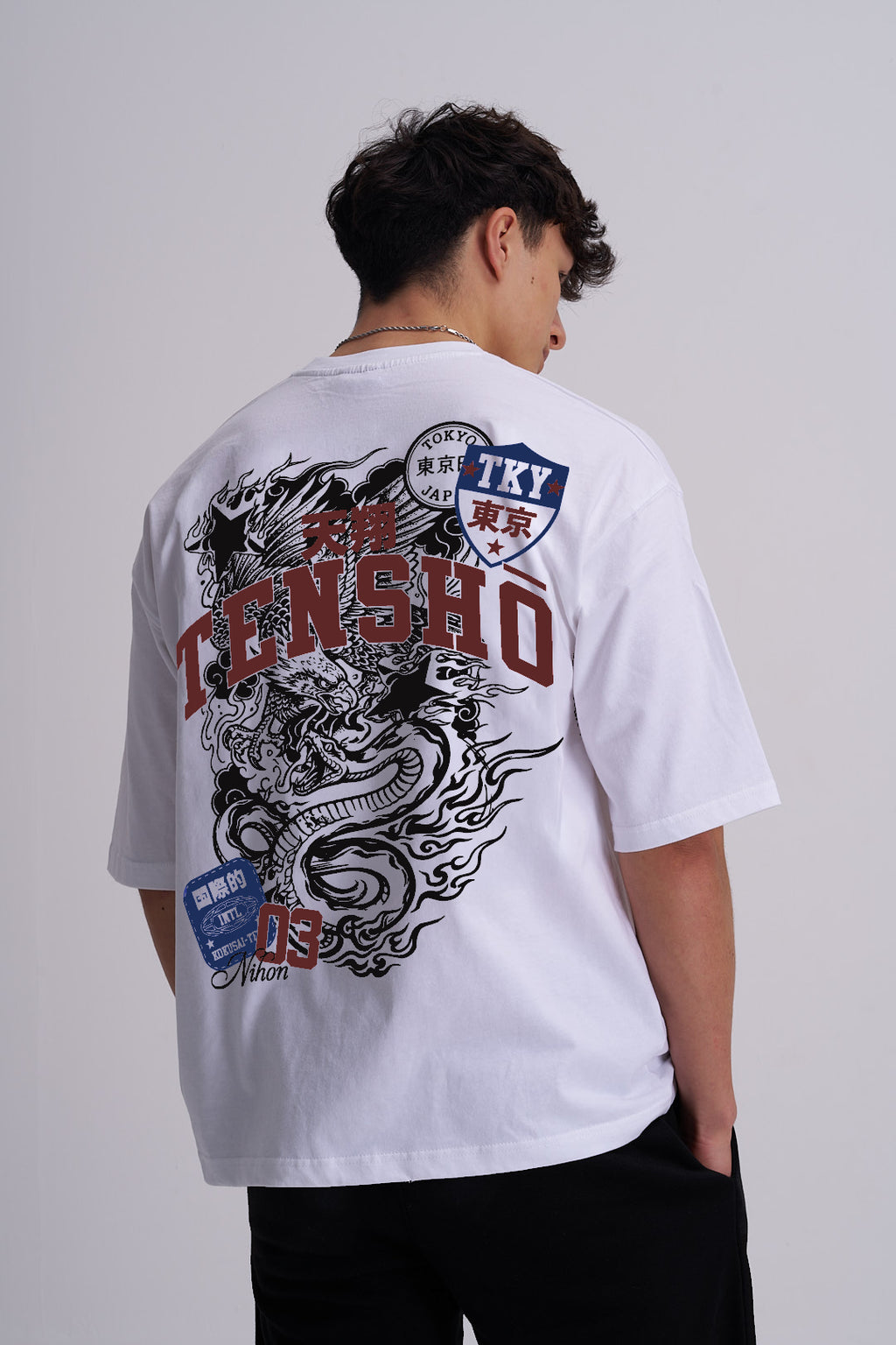 Man wearing a white t-shirt with Japanese dragon design and text on the back.