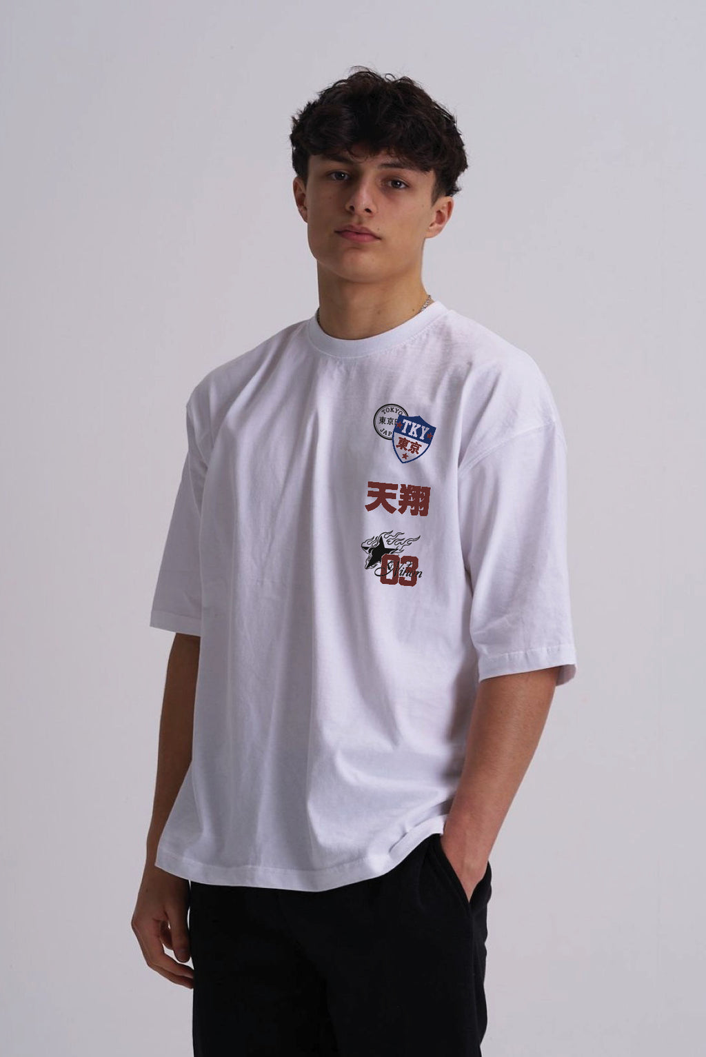Man wearing a white t shirt with Japanese badge design on the front