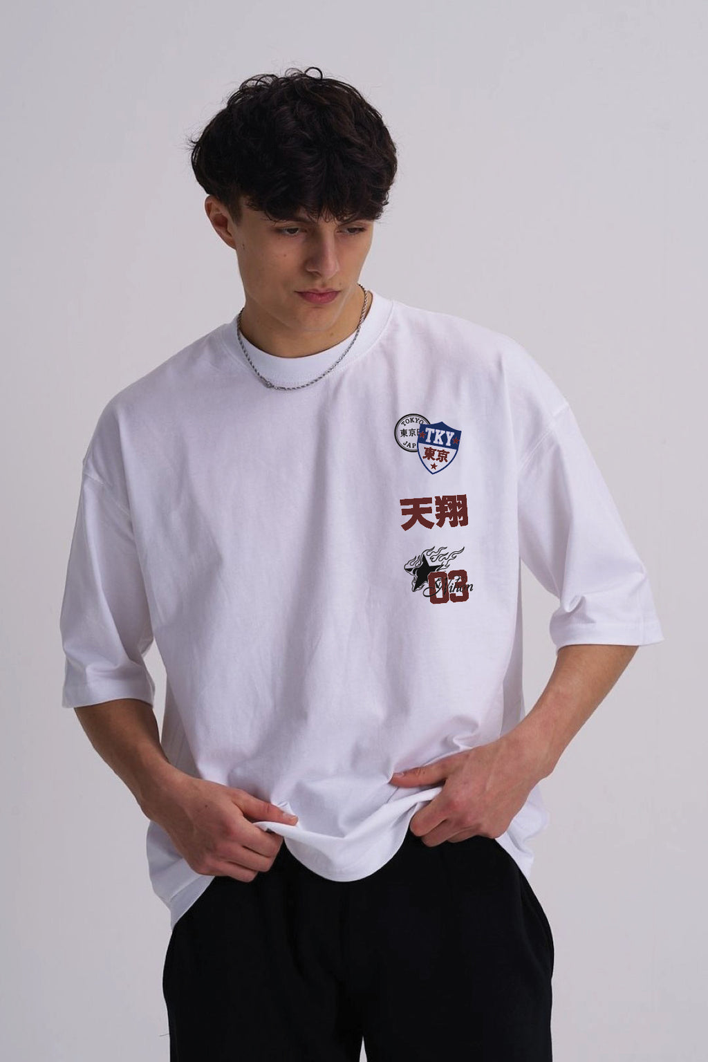 Man wearing a white t shirt with Japanese badge design on the front
