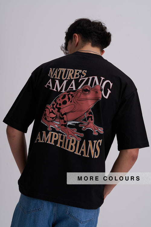A man viewed from behind wearing a black t-shirt with a large graphic print of a red and black spotted frog and the text 'NATURE'S AMAZING AMPHIBIANS'.