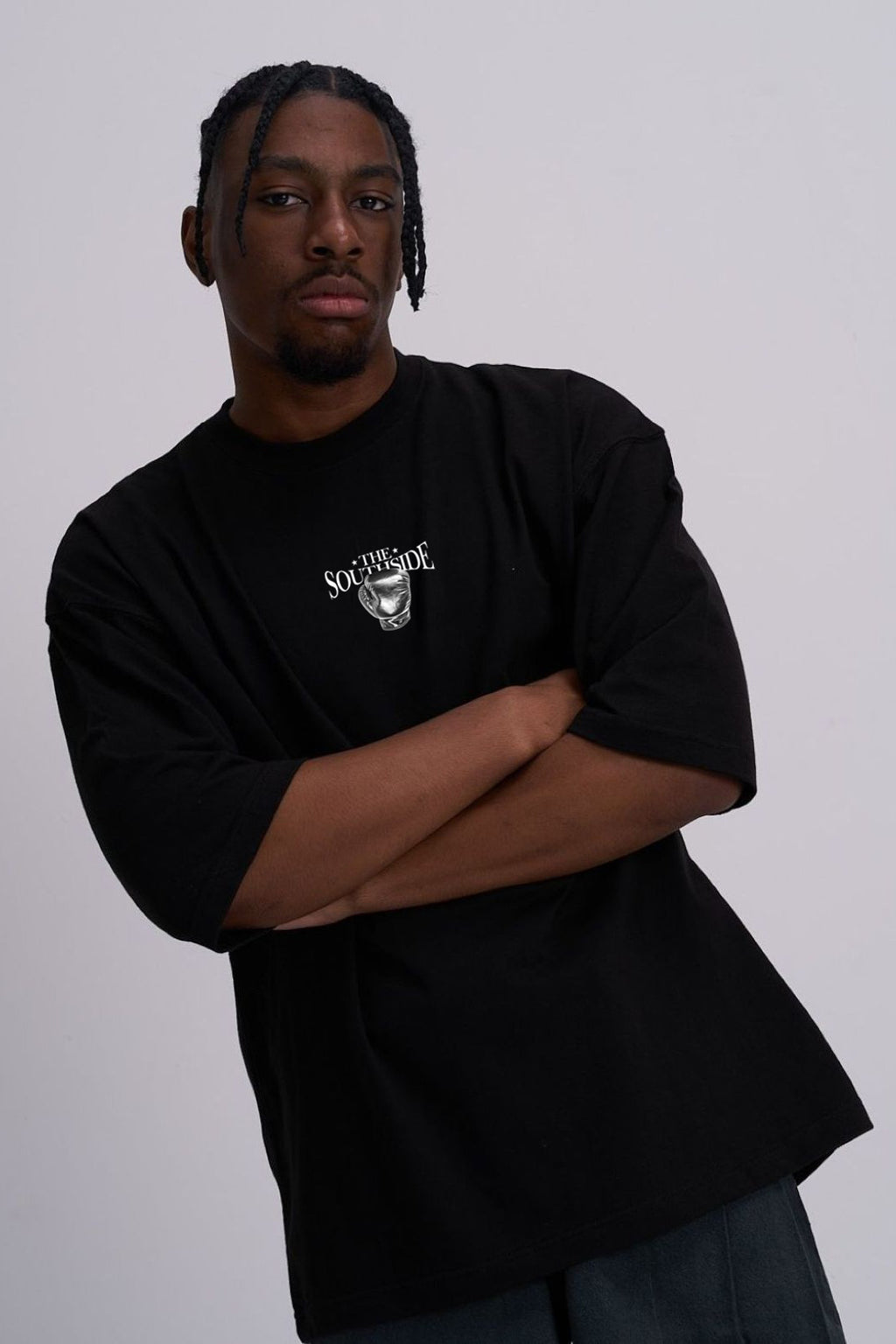 Person wearing a black t-shirt with a boxing glove logo on a white background