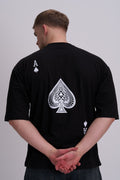 Man wearing a black t-shirt with a white spade design on the back against a grey background