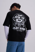 Male wearing a black t-shirt with a retro music vinyl player graphic design on the back, standing against a plain background.