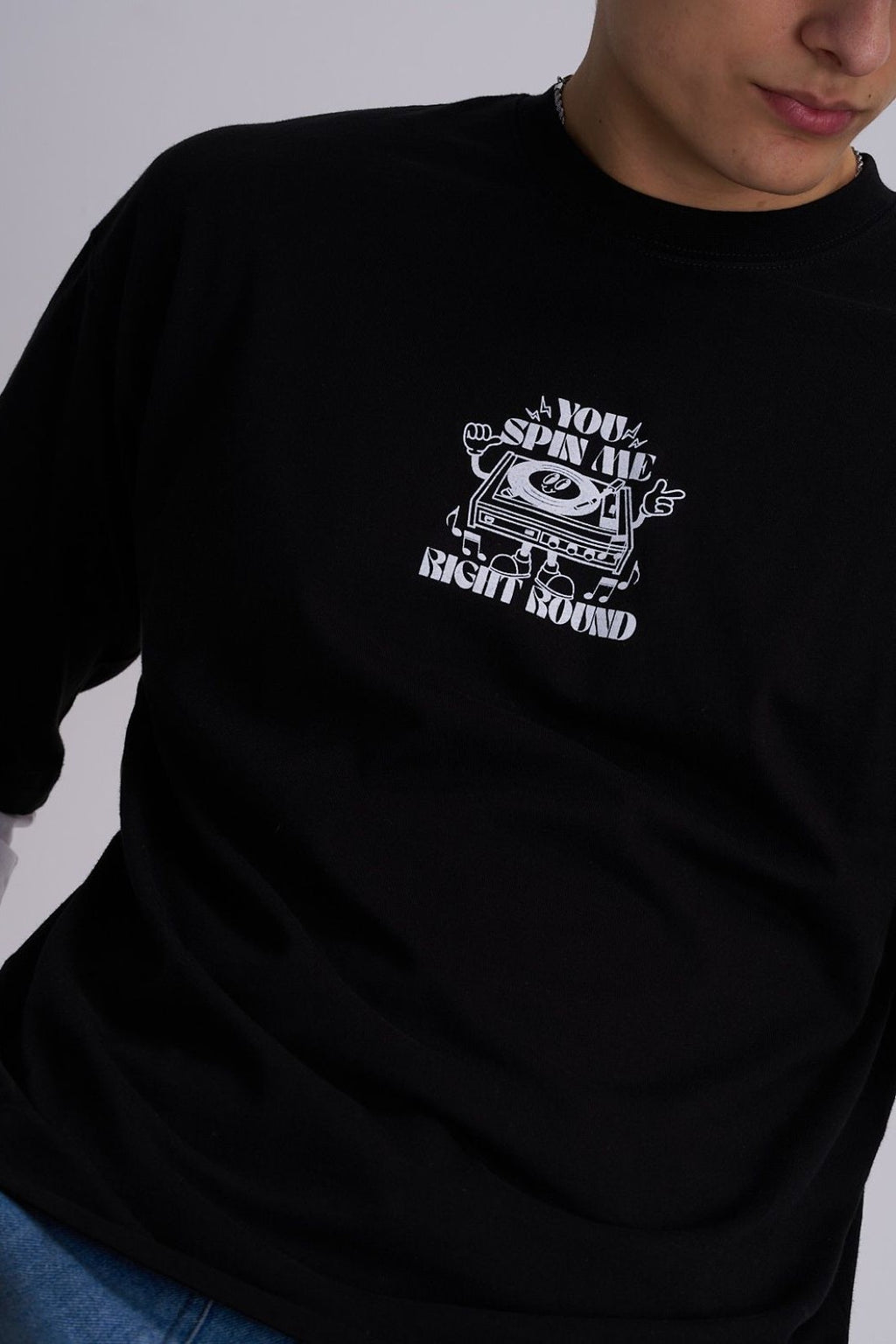 Black t-shirt with white vinyl player graphic design and text on a plain background