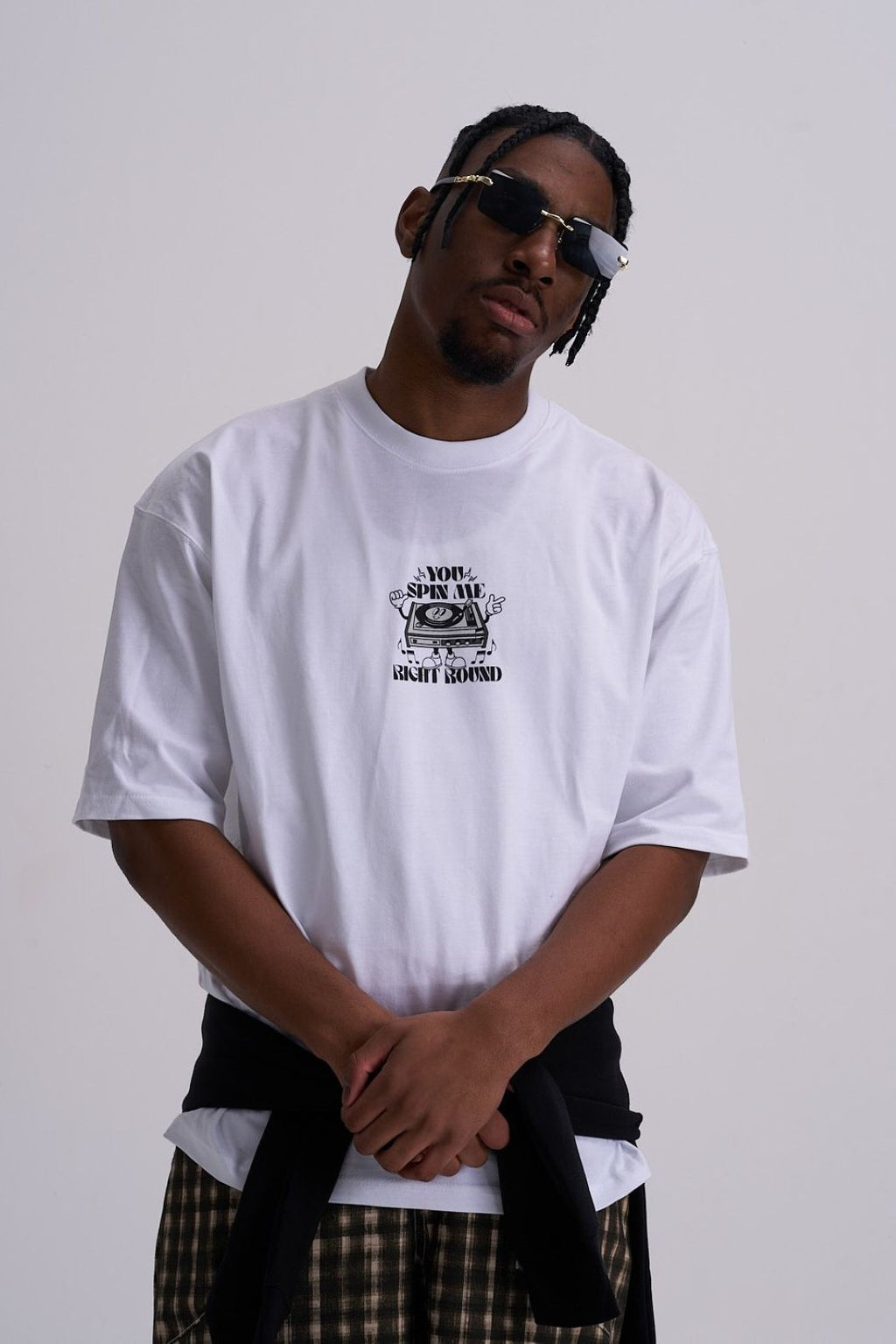 male wearing a white t-shirt with a graphic retro music design on a plain background