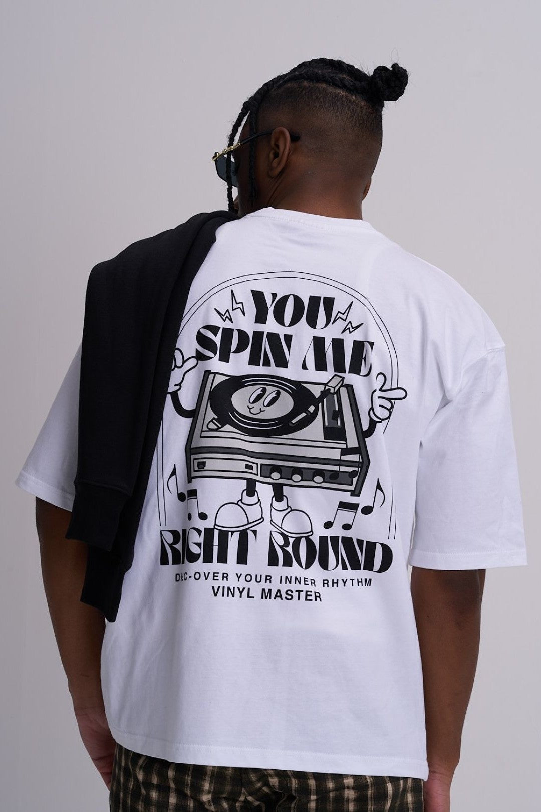 Male wearing a white t-shirt with a graphic design on the back, standing against a plain background.