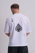Male wearing a white t-shirt with a black spade design on the back against a plain background