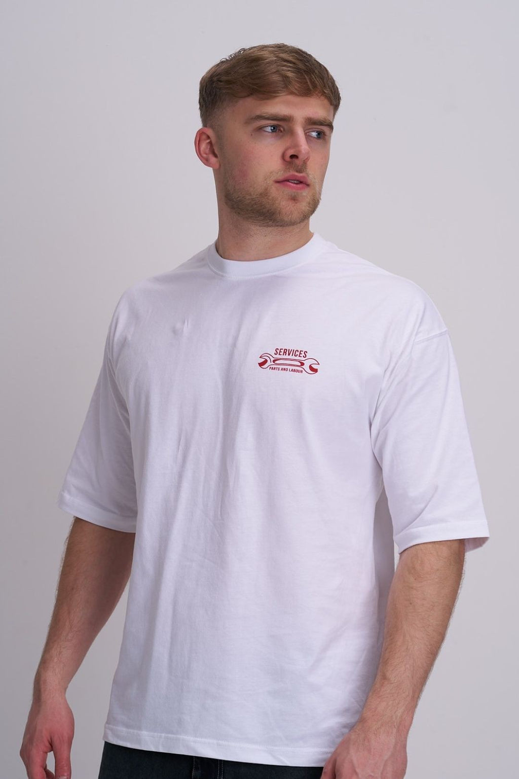 Man wearing a white t-shirt with a red  spanner logo on a plain background